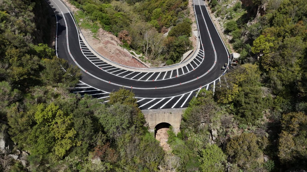 Mountain hairpin curve with fresh asphalt and chevron markings